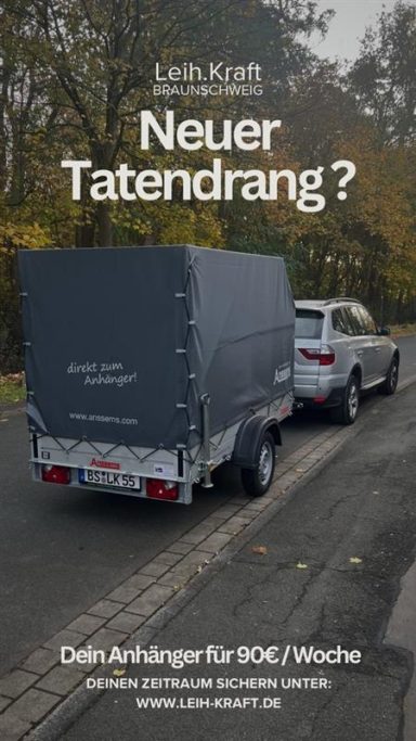 Anhänger: 750kg gebremst Ein Fahrzeug mit Anhänger auf einer Straße, umgeben von Bäumen im Herbst.